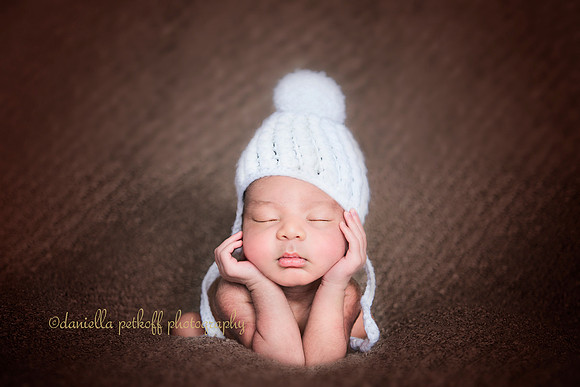 Newborn sitting in a frog pose