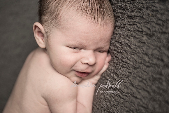 Newborn baby boy smiling in his sleep