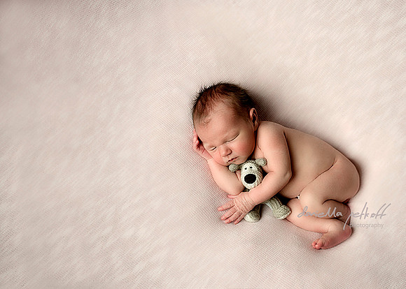 Newborn baby girl with knitted doggy